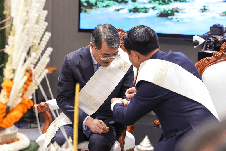 Thủ tướng Chính phủ Lào Saleumxay Kommasith buộc chỉ cổ tay cho Thủ tướng Chính phủ Lê Minh Hưng - Ảnh: chinhphu.vn/Nhật Bắc